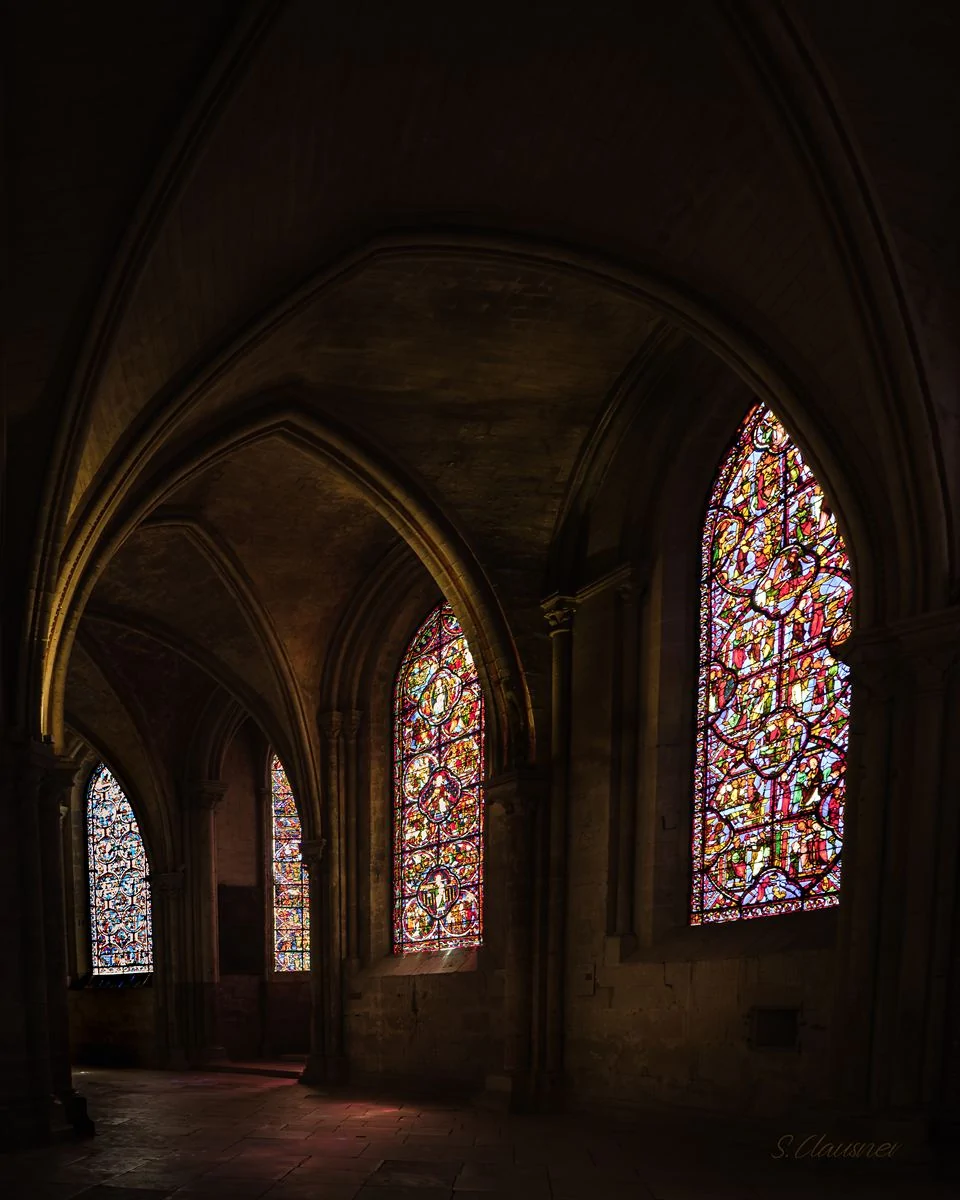 Bas-côté d’église éclairé par de grands vitraux